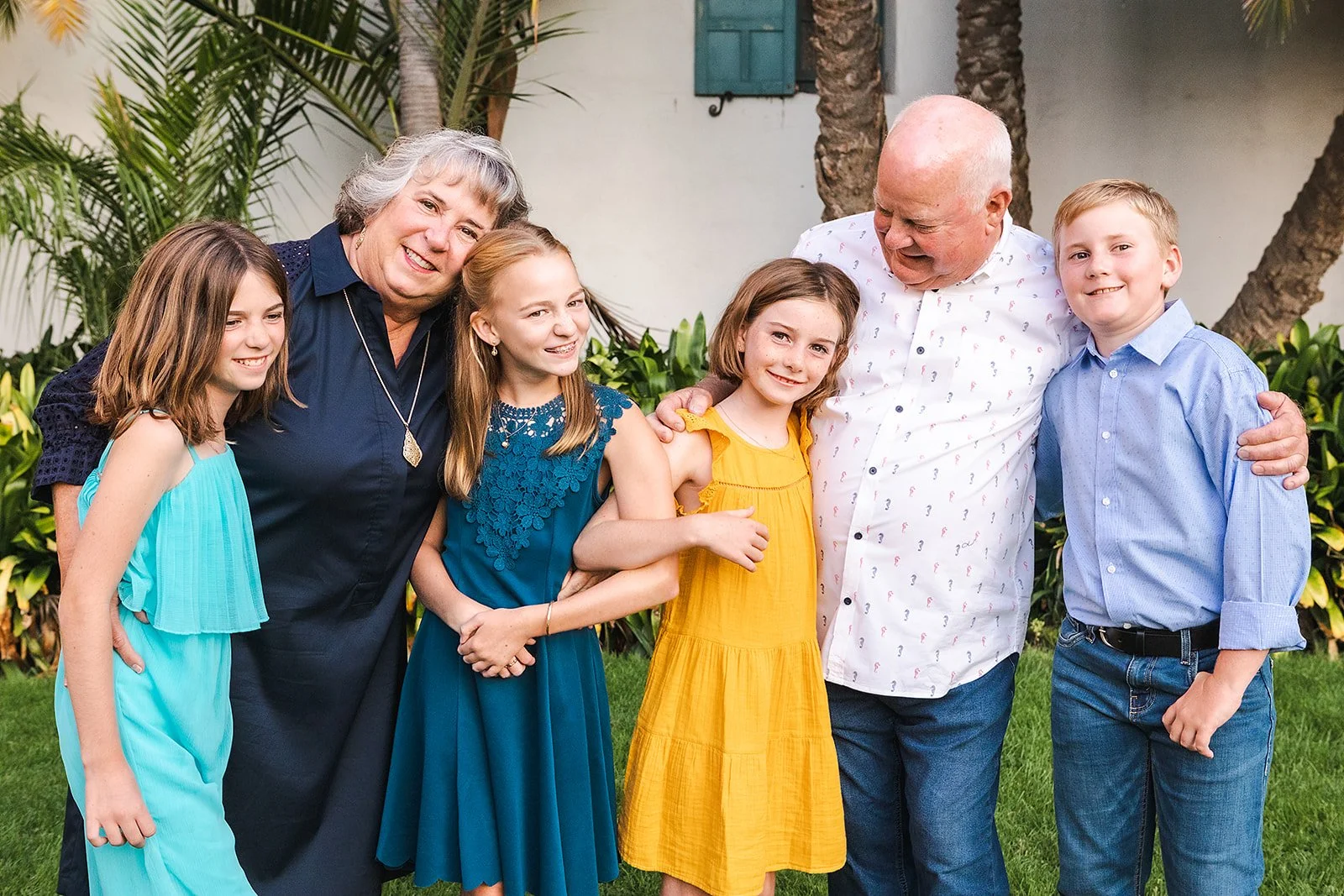Family portait of grandkids and grandparents wearing jewel tones at their family photo session.