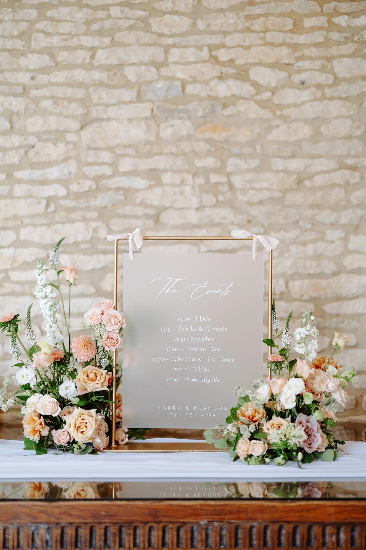 frosted acrylic signage on a wooden table styled with beautiful fresh florals 