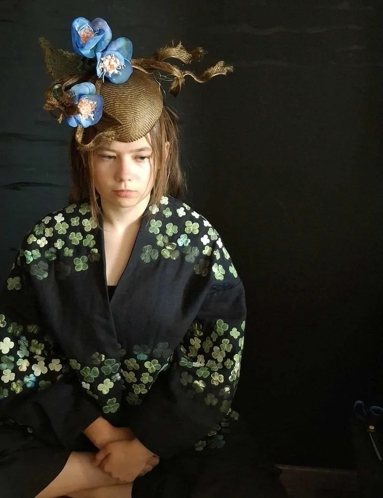 Czarny lniany płaszczyk z motywem koniczyny i sylwetką białego królika, artystyczna kufajka bez zapięcia, z szerokimi marszczonymi rękawami.