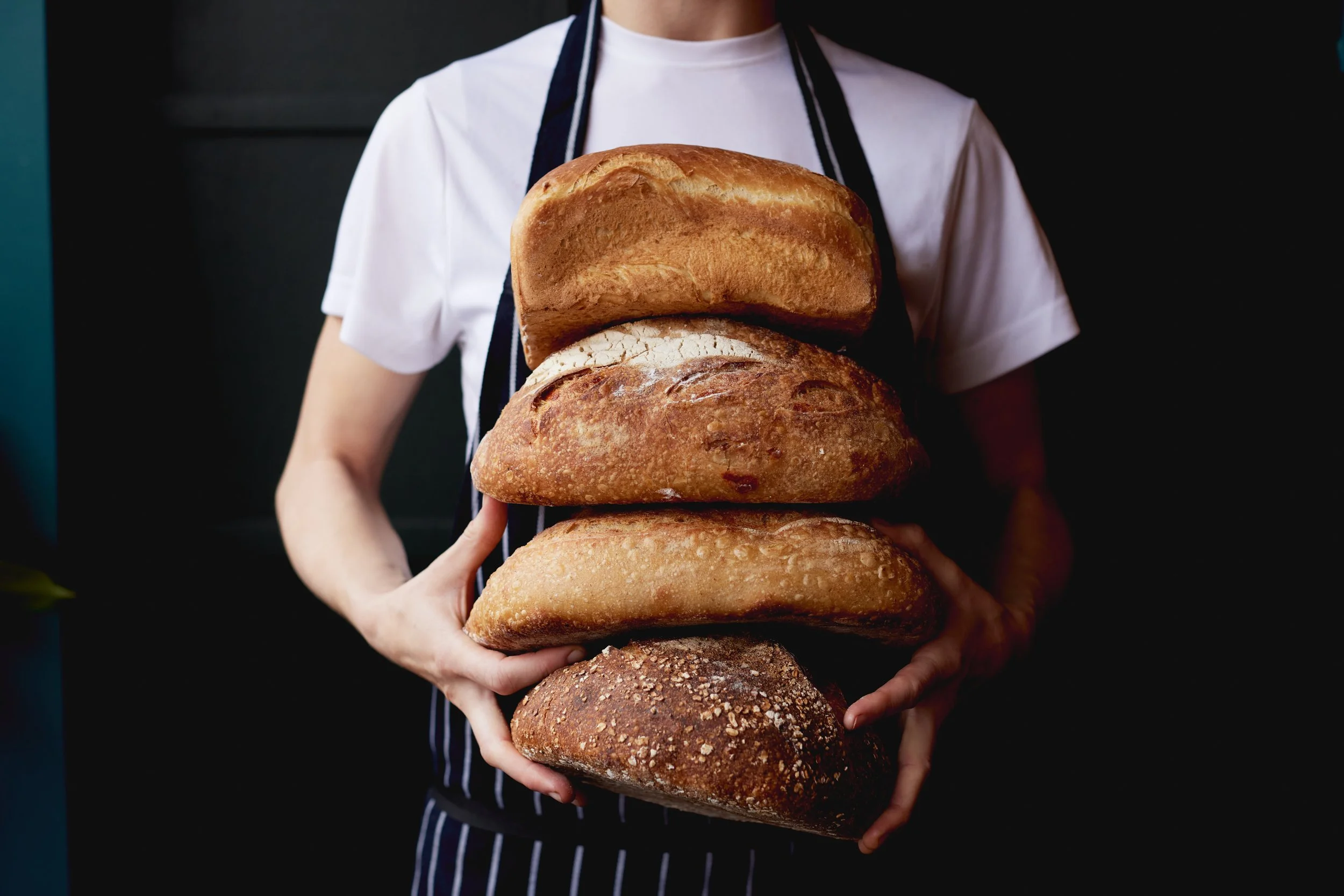 Five Little Pigs staff holding locally sourced bread