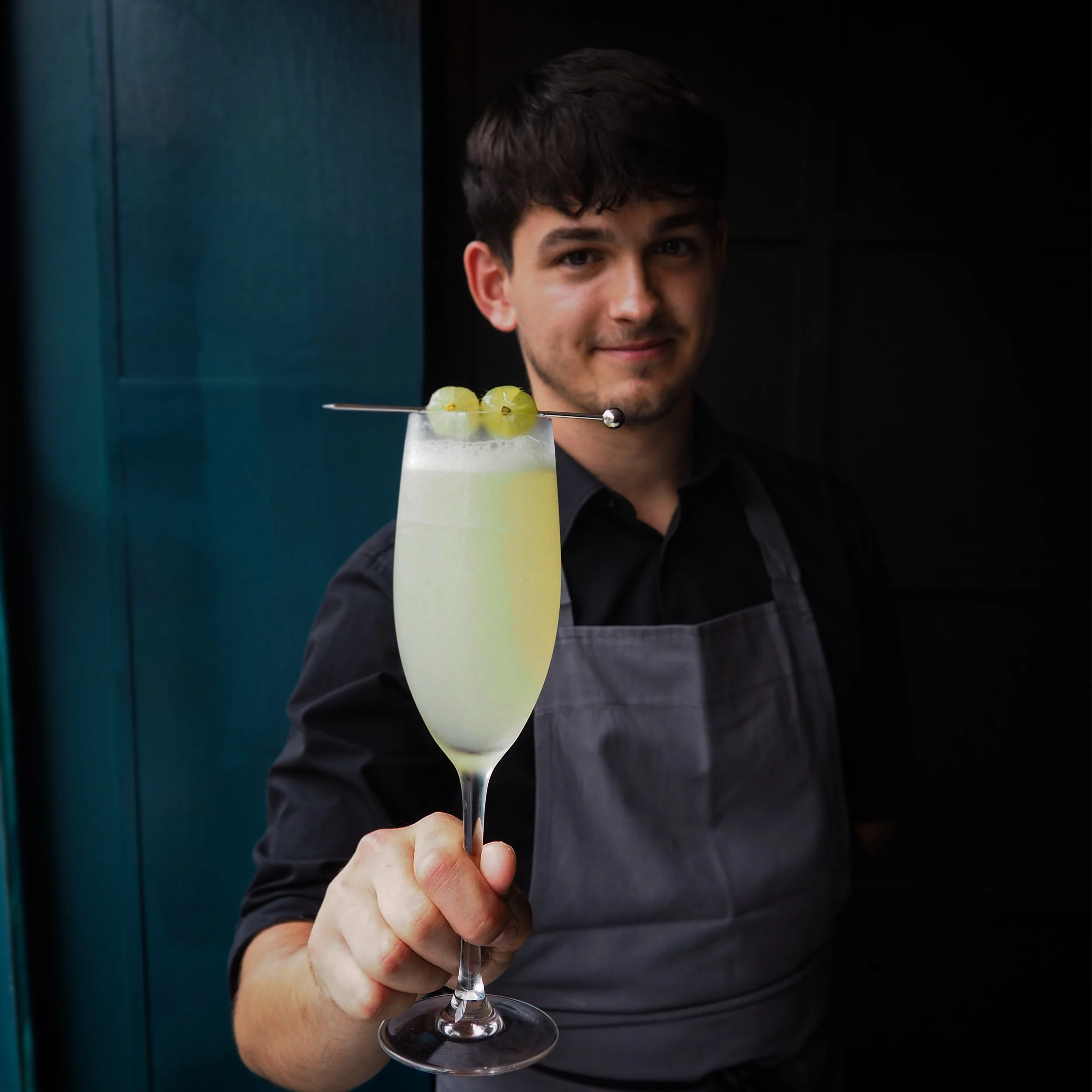 Five Little Pigs bar manager holding a carefully crafted cocktail