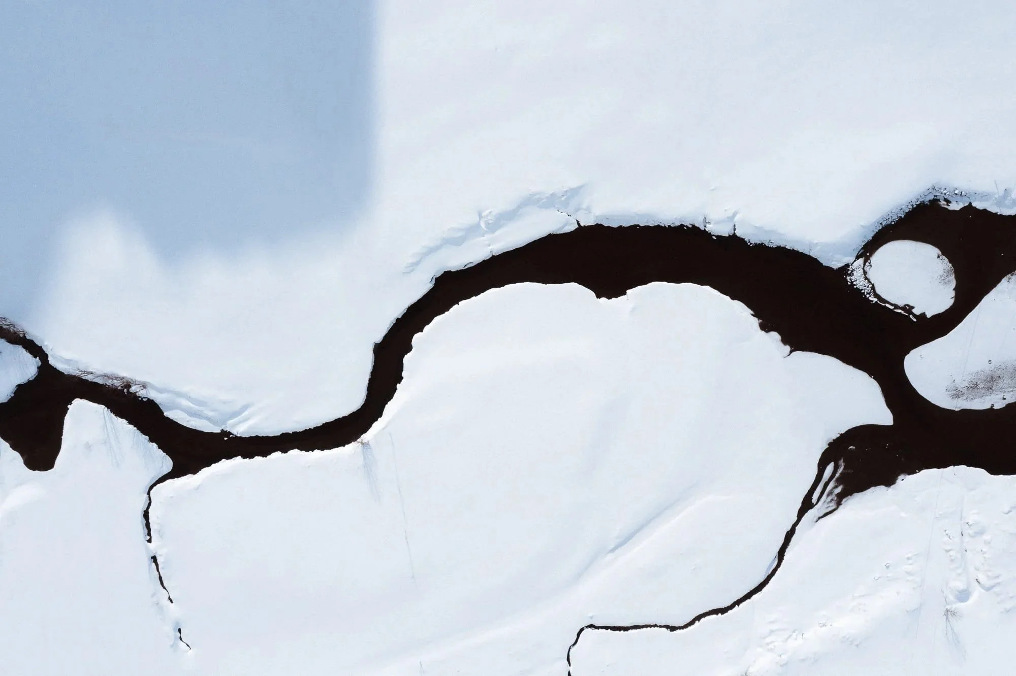 Close-up of a broken wall or surface with exposed dark material and torn white paper around the edges.