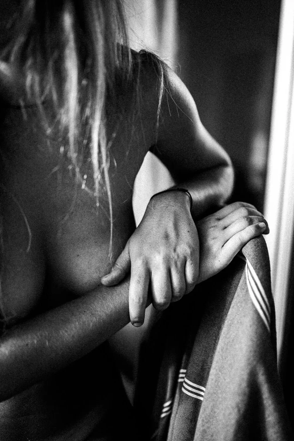 Personne nue tenant une serviette, photographie en noir et blanc.