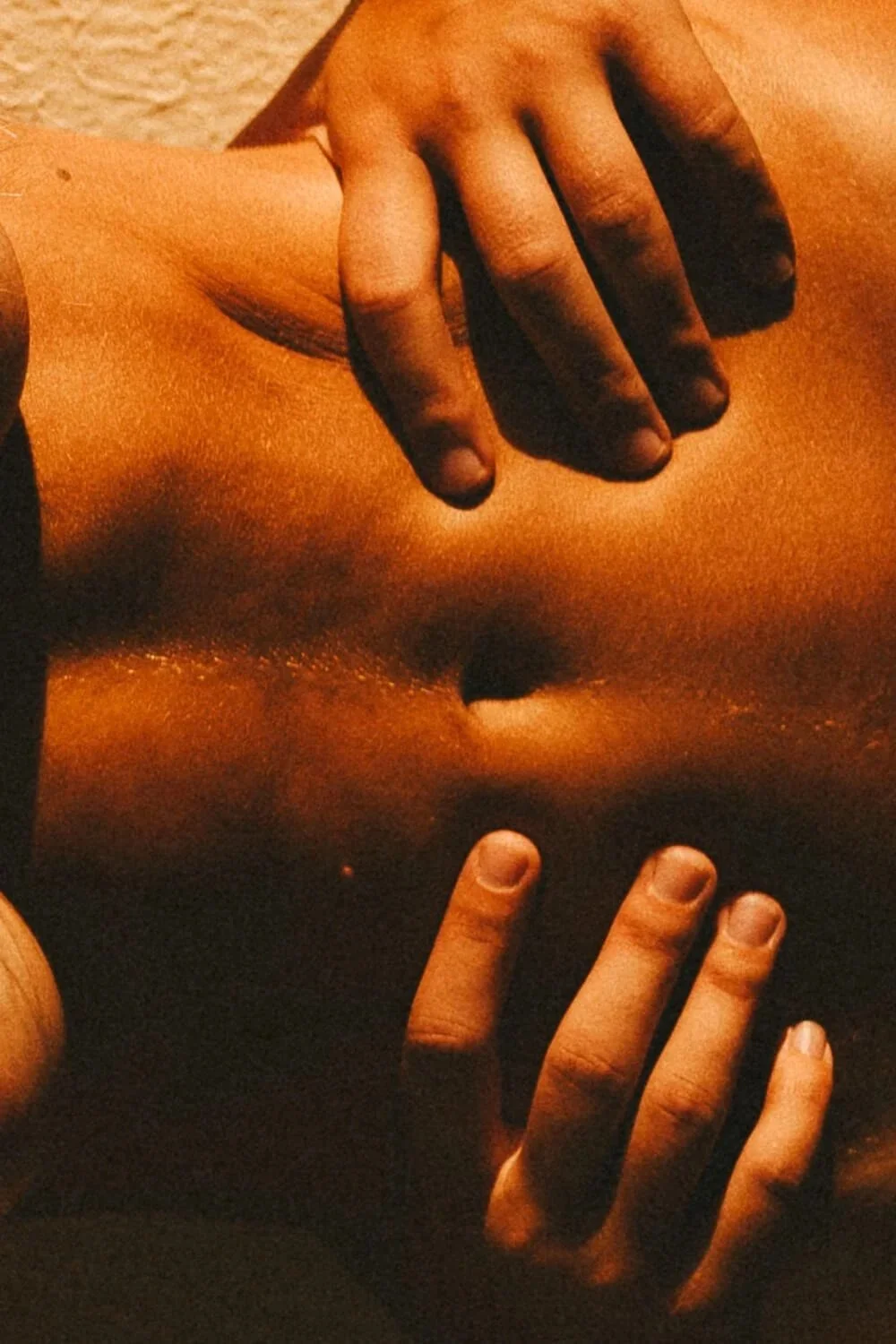 Corps humain, main posée sur un torse bronzé.
