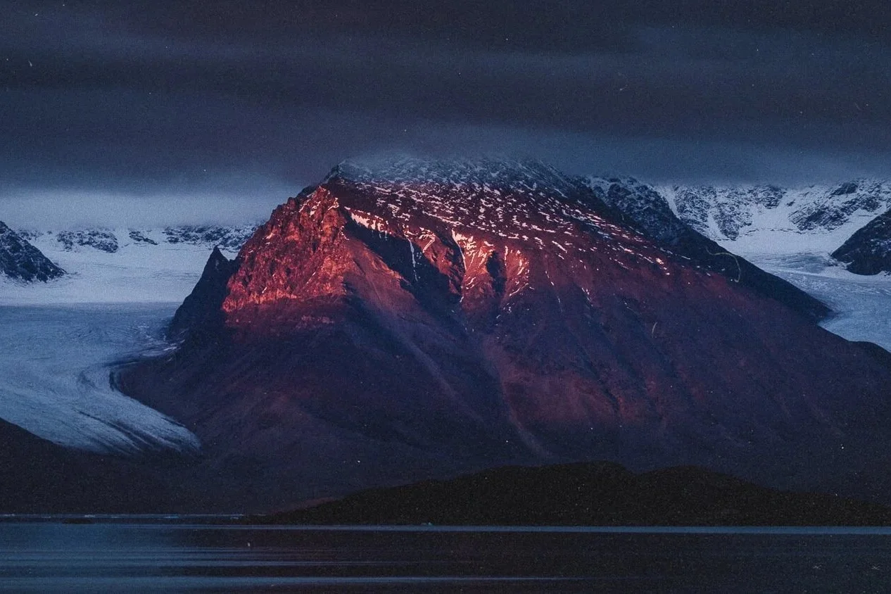 Montagne éclairée par le soleil couchant avec glacier en arrière-plan.