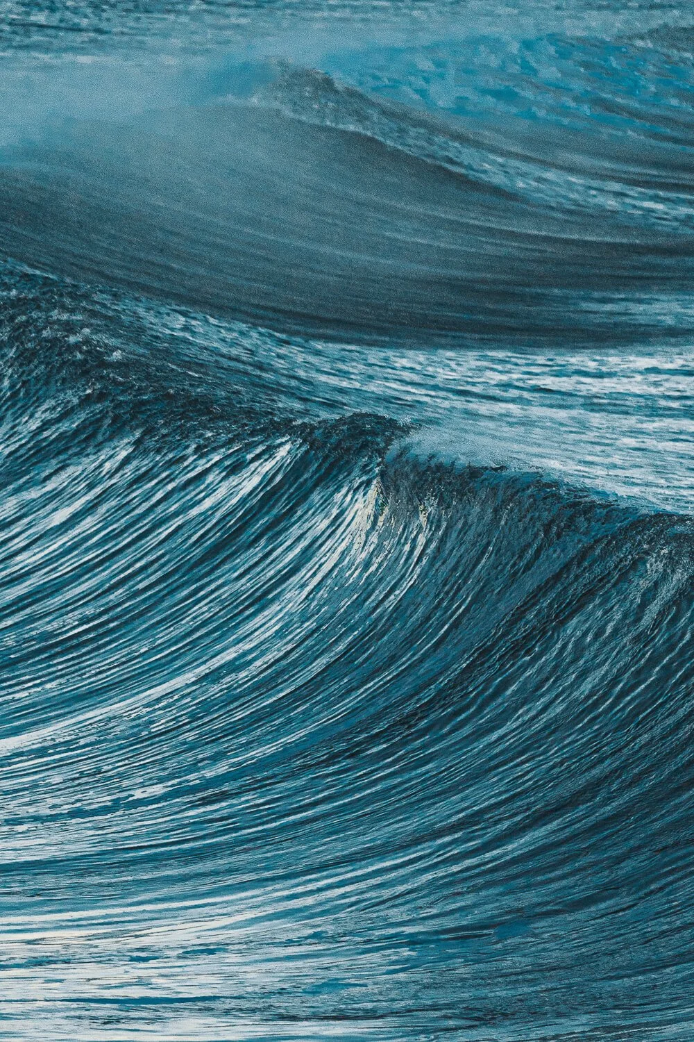 Close-up of ocean waves with foamy crests and ripples.