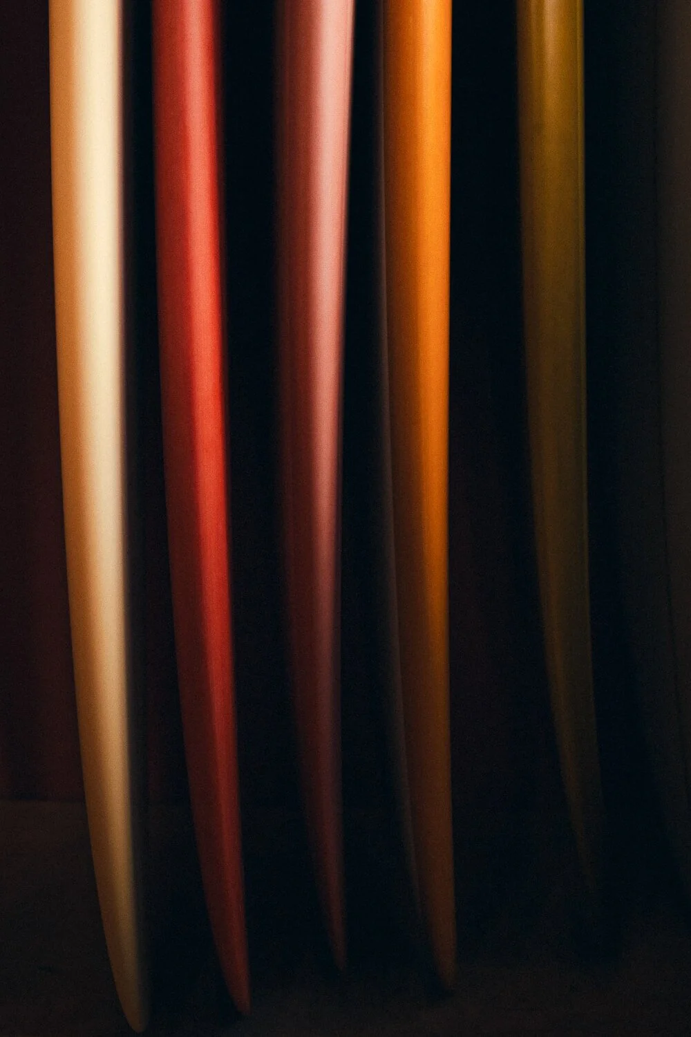 Close-up of several colorful wooden sticks or paddles, arranged vertically in a dark setting.
