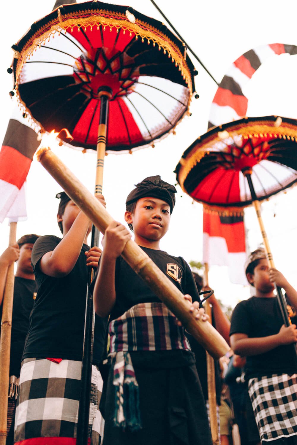 Groupe d'enfants participant à un festival culturel, portant des costumes traditionnels et tenant des parasols colorés lors d'une célébration