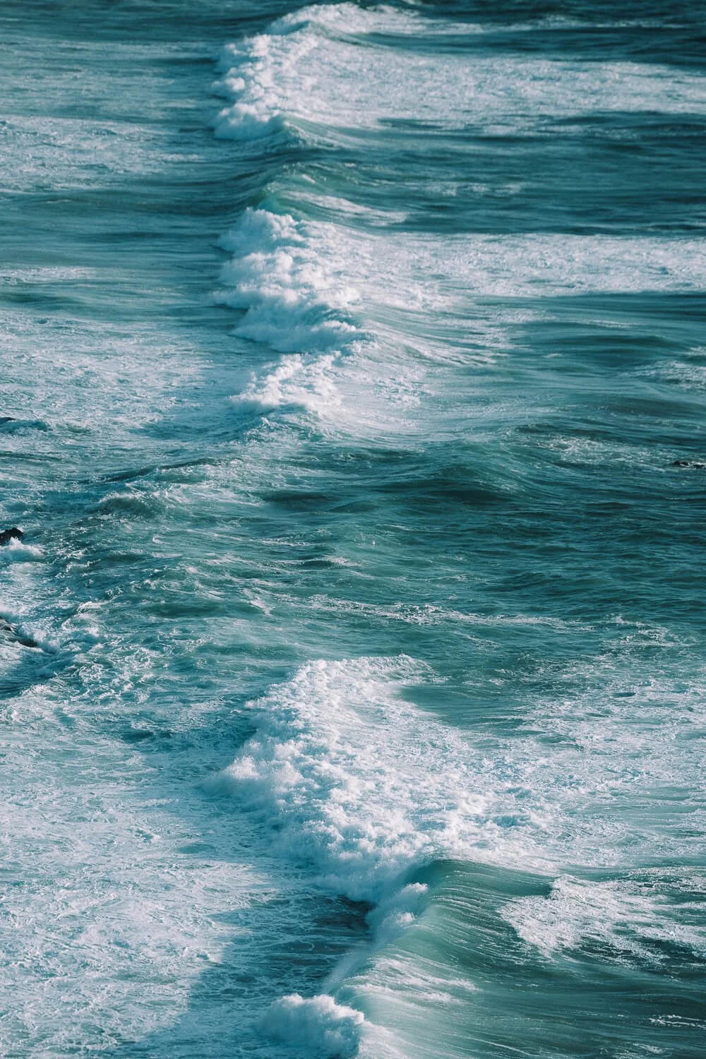 Ocean waves with foam on the surface, showing the motion of the water.