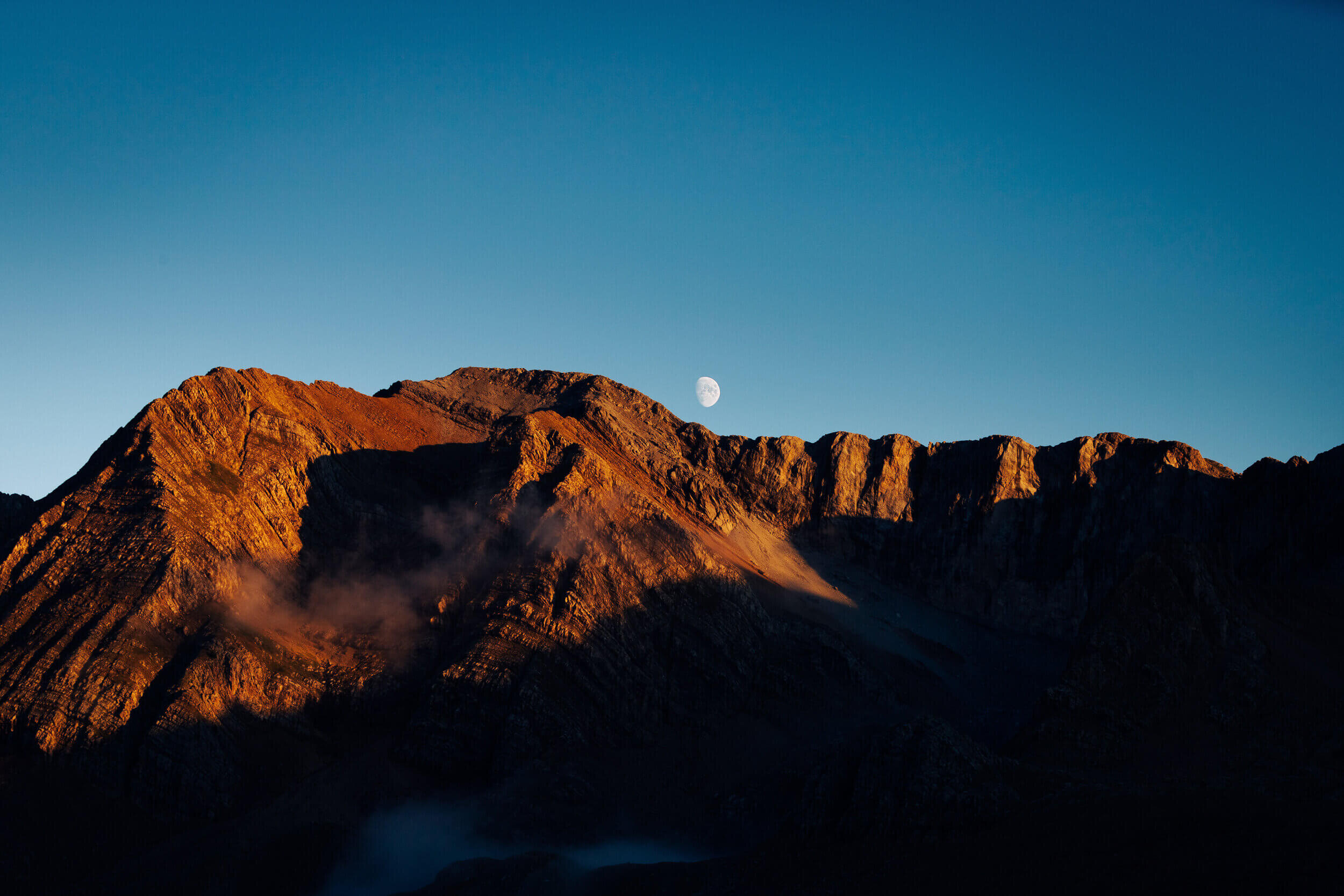 Paysage de montagnes au coucher du soleil avec la lune.