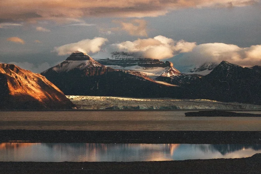Montagnes avec des sommets enneigés, reflet dans un lac dans un paysage naturel
