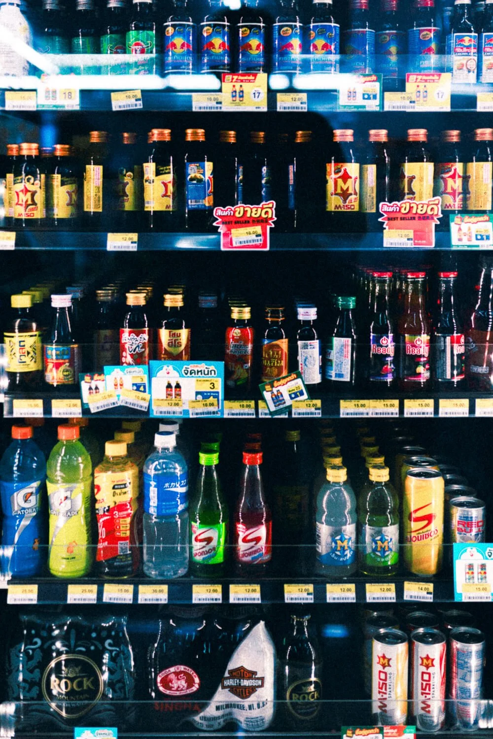 Rayonnage de boissons gazeuses, thés et energy drinks en bouteille dans un supermarché.