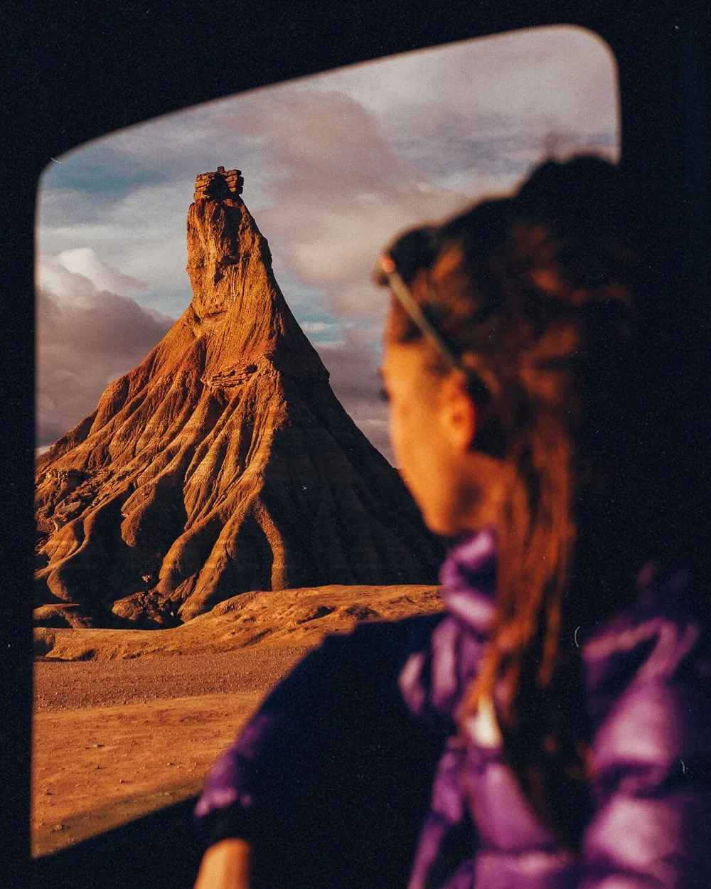 Vue d'une femme regardant la formation rocheuse de la montagne de Totem en Amérique du Sud, prise depuis une fenêtre ou un véhicule, au coucher du soleil.