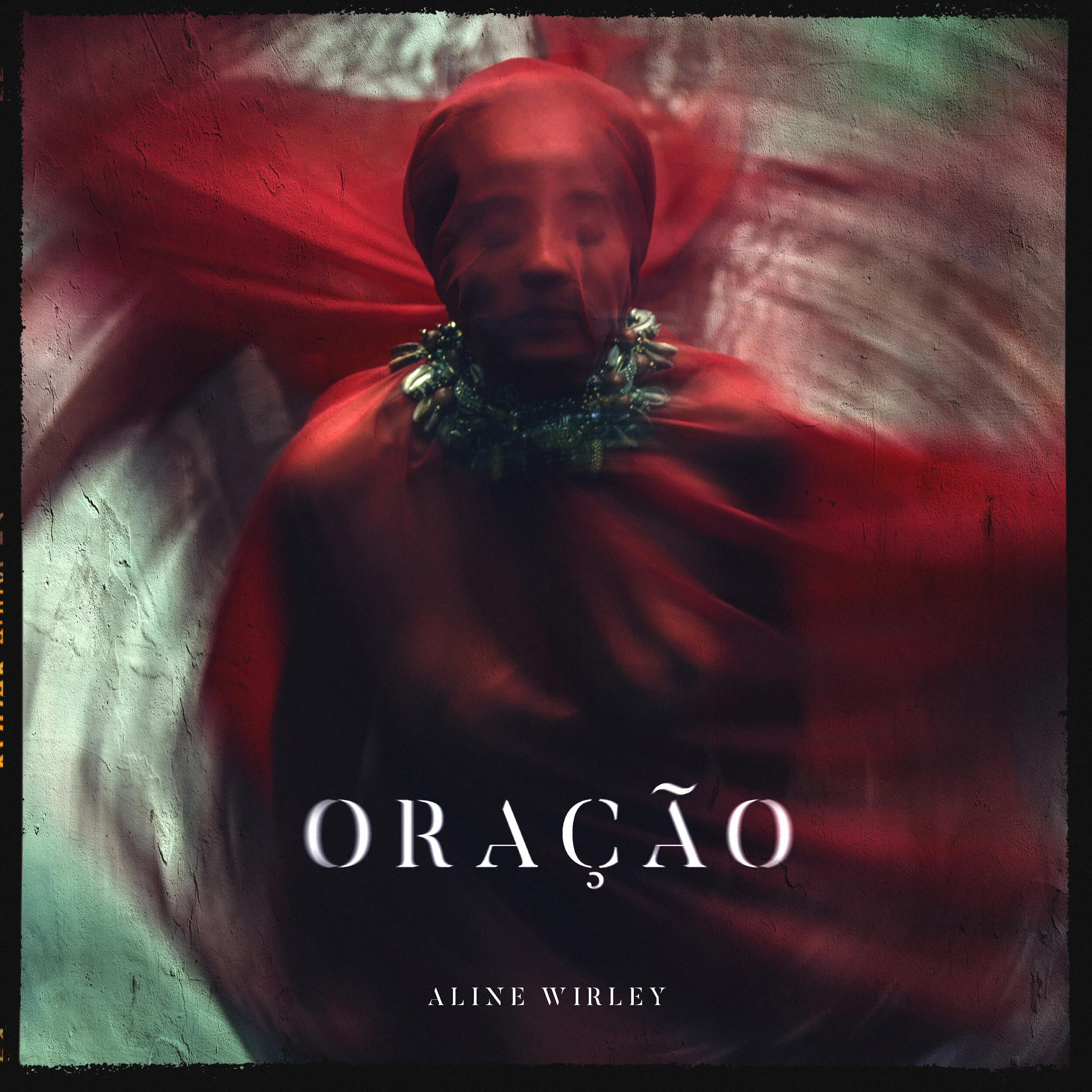 Cena de uma mulher usando um lenço vermelho na cabeça, com roupas da mesma cor, e usando uma joia grande de colar. A imagem tem efeito artístico e as palavras "O aroma" e o nome "Aline Wirley" aparecem na parte inferior.