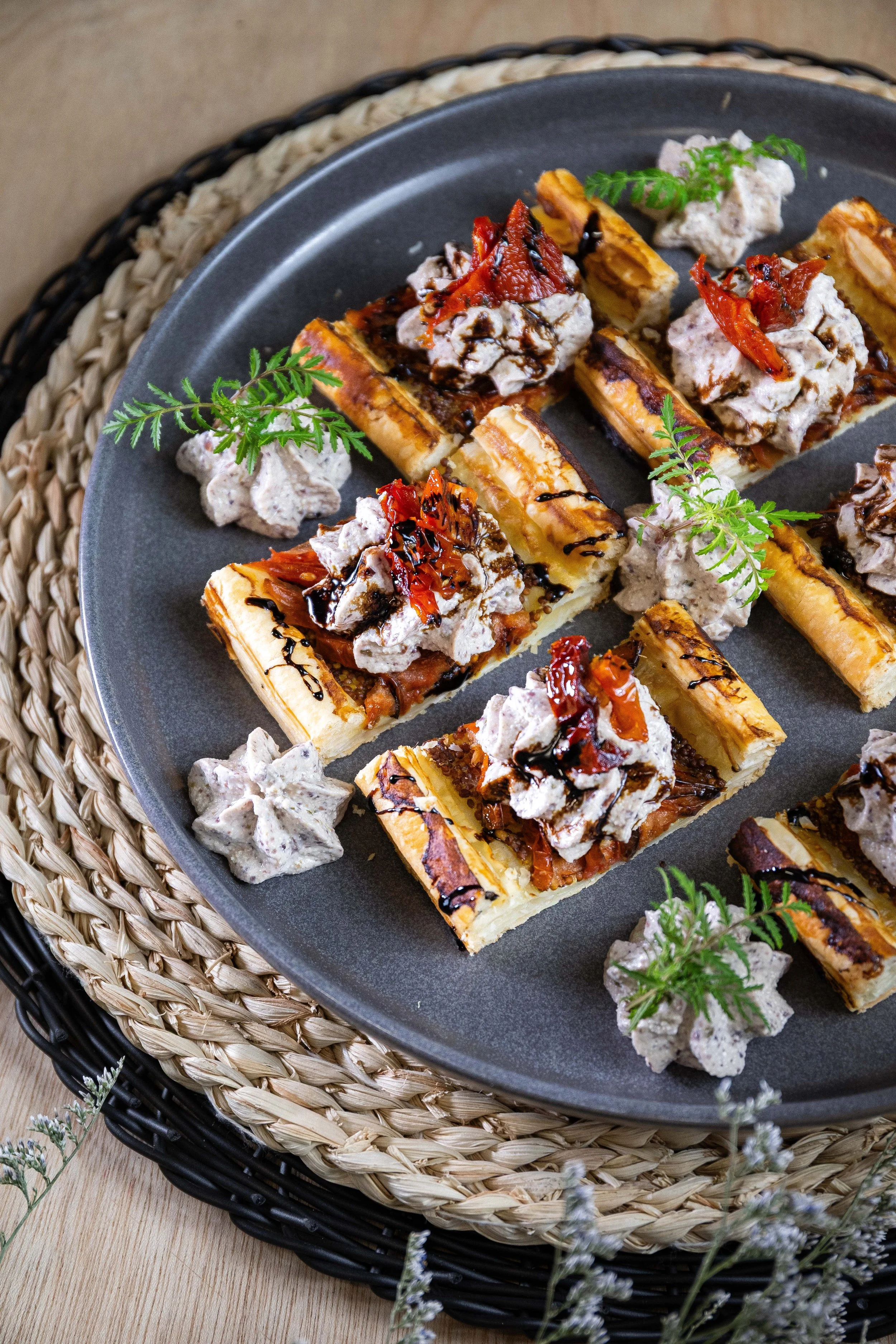 Mini tartes avec des bananes grillées, chantilly à la vanille et garniture de chocolat, décorées de feuilles de verdure.