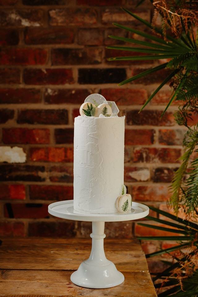 Snowdrop Cakery wedding cake photographed on an industrial exposed brick background