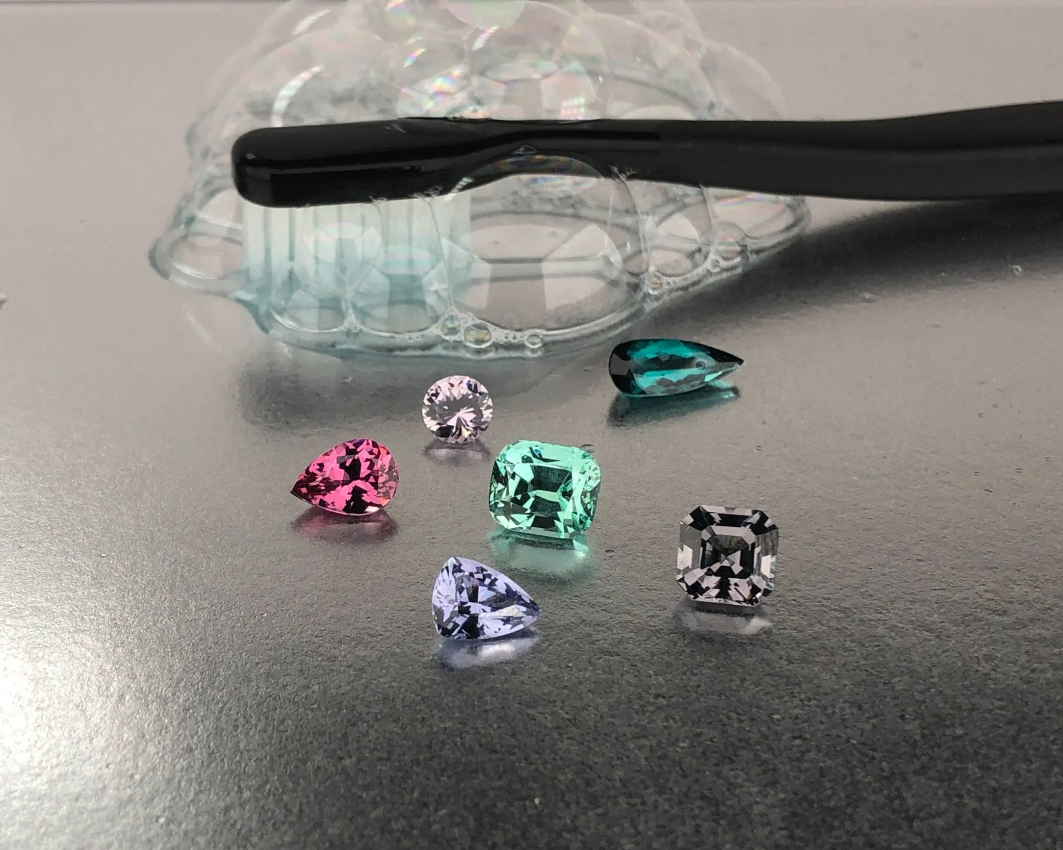 Cleaning natural gemstone jewelry with warm water and mild dish soap as part of a safe jewelry care routine.