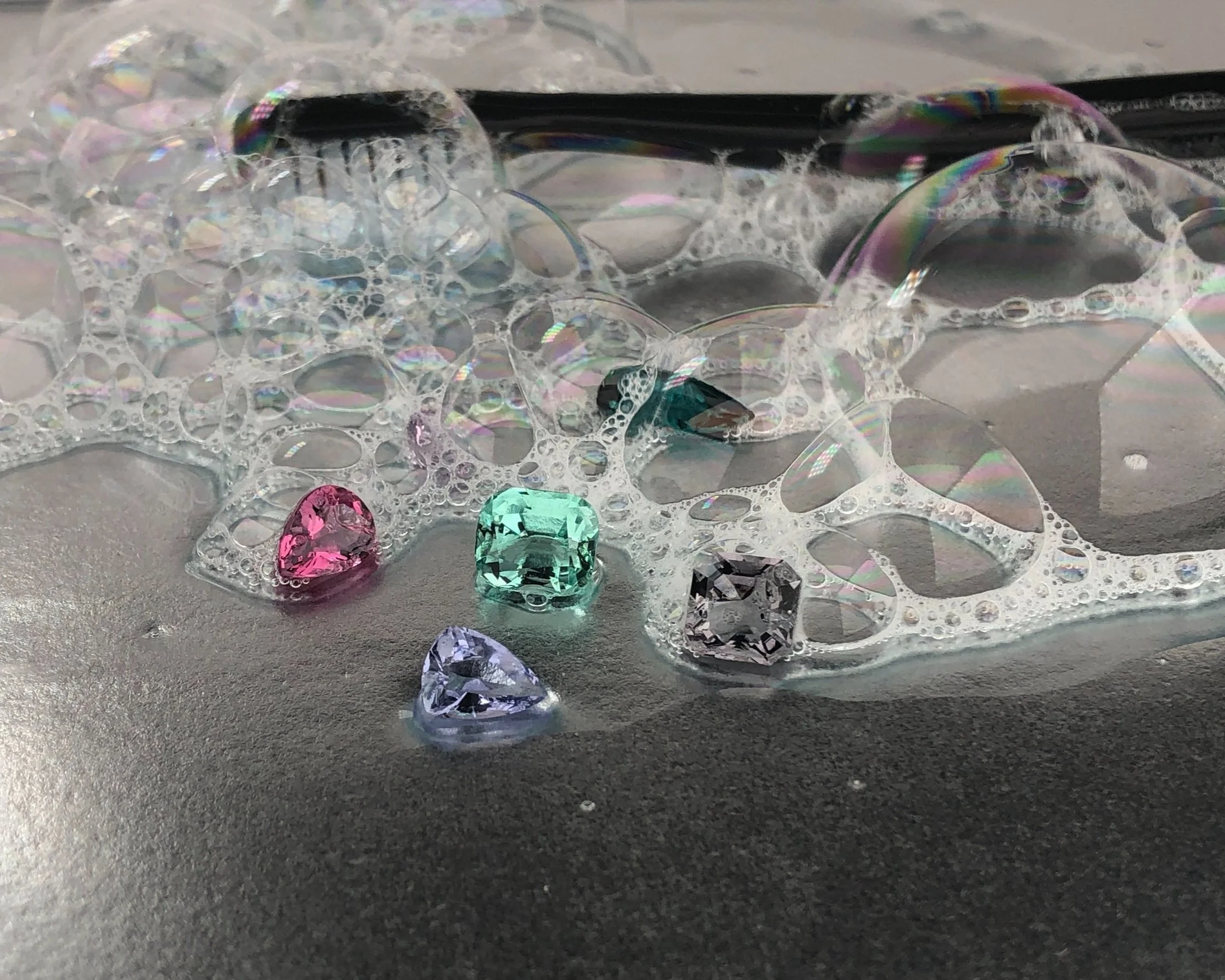 Fine jewelry care guide demonstrating the proper way to rinse natural gemstone jewelry after cleaning.