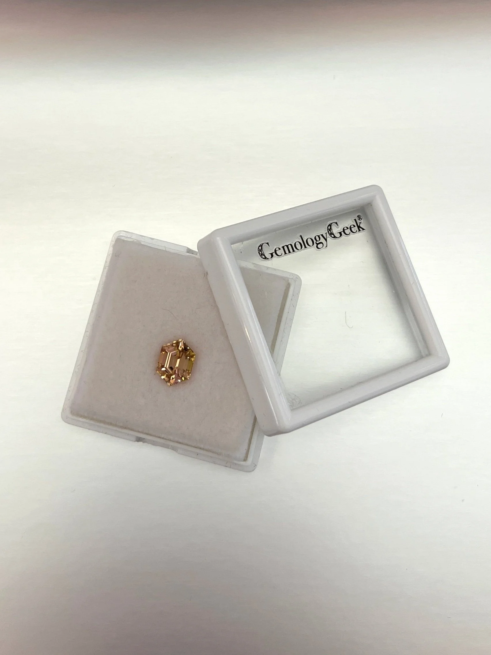 A 2.06 carat bi-color peach tourmaline with a hexagon cut, displaying stunning peach hues and exceptional clarity, highlighting its unique and elegant gem quality.