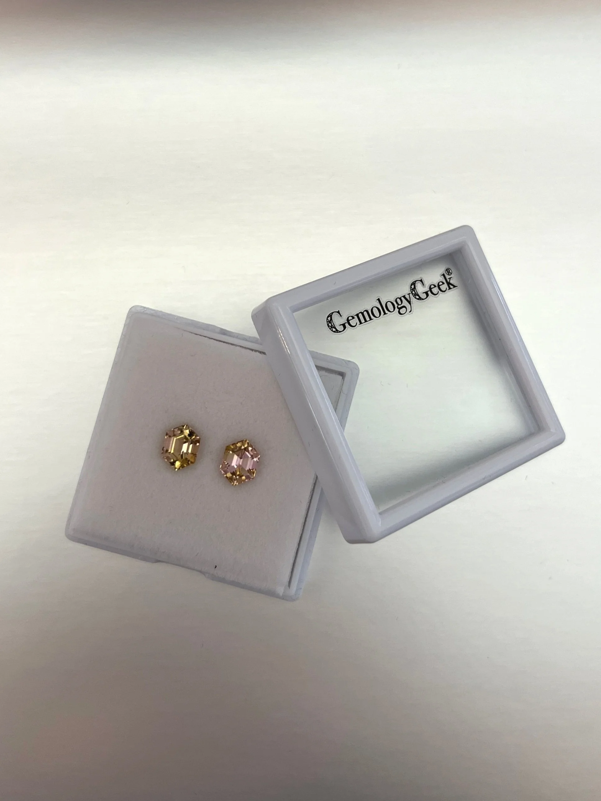 A set of bi-color peach tourmalines with a total weight of 2.23 carats, each featuring a hexagon cut and showcasing beautiful peach hues, highlighting their unique and elegant gem quality.