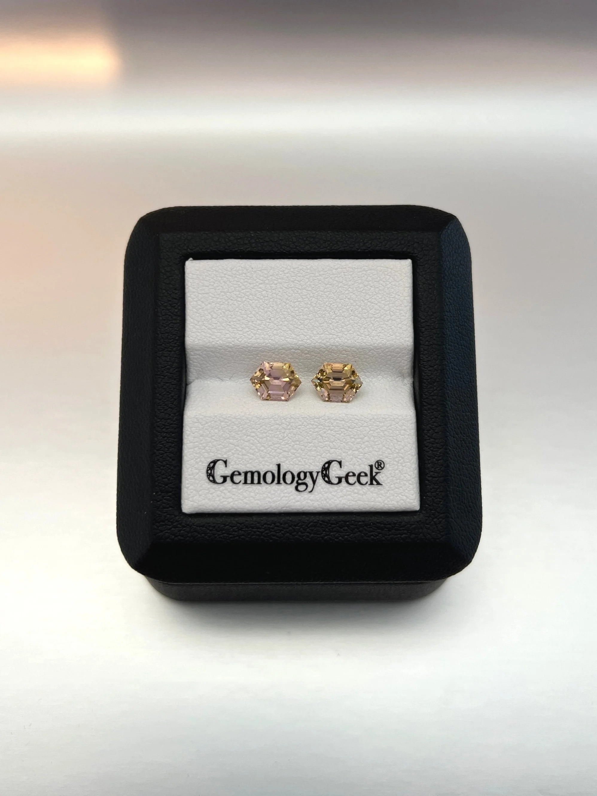 A set of bi-color peach tourmalines with a total weight of 2.23 carats, each featuring a hexagon cut and showcasing beautiful peach hues, highlighting their unique and elegant gem quality.