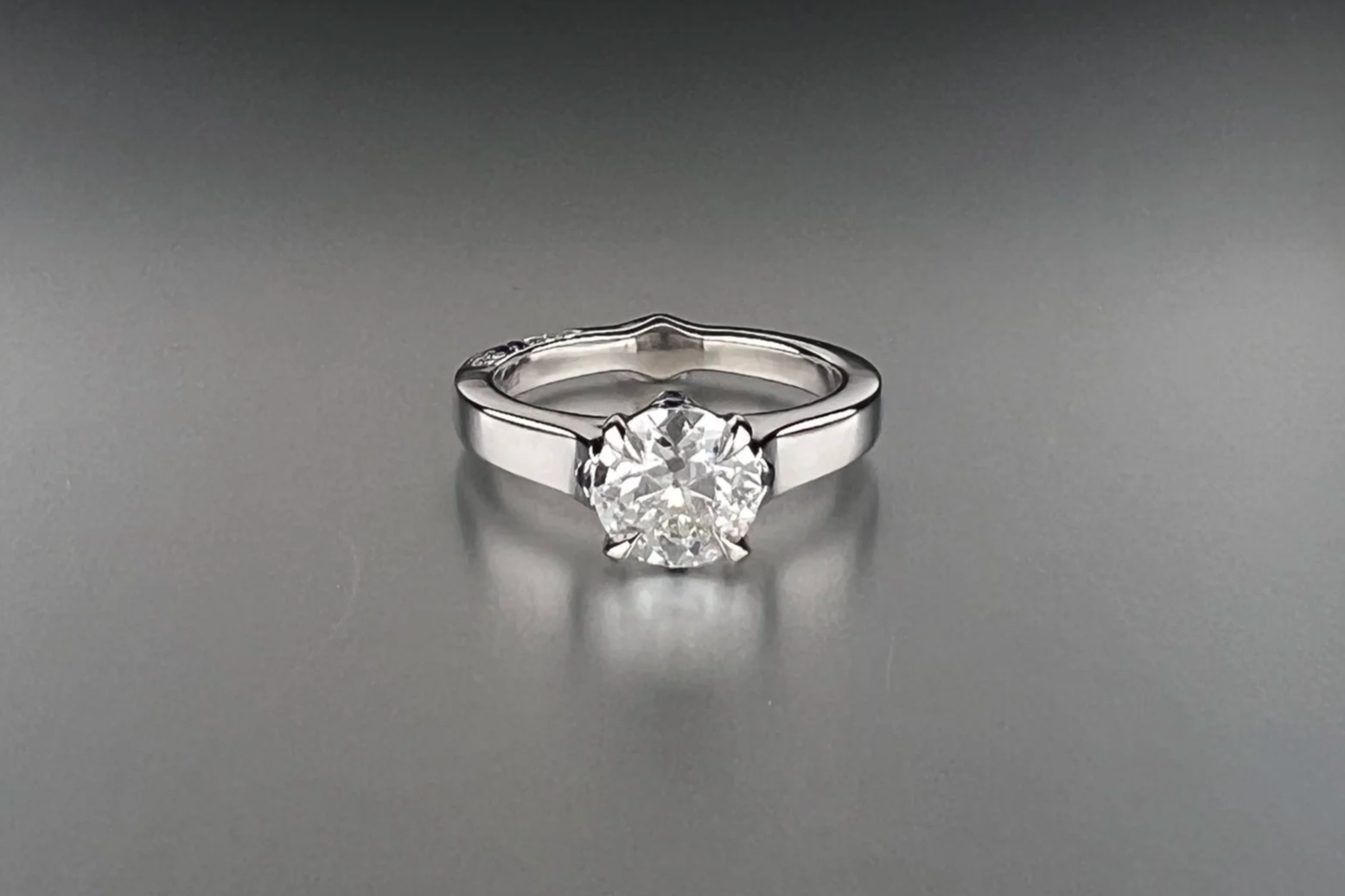 Front view of a custom platinum engagement ring featuring a 1.35 ct Old European cut natural diamond with pavé natural diamonds and blue sapphire accents.