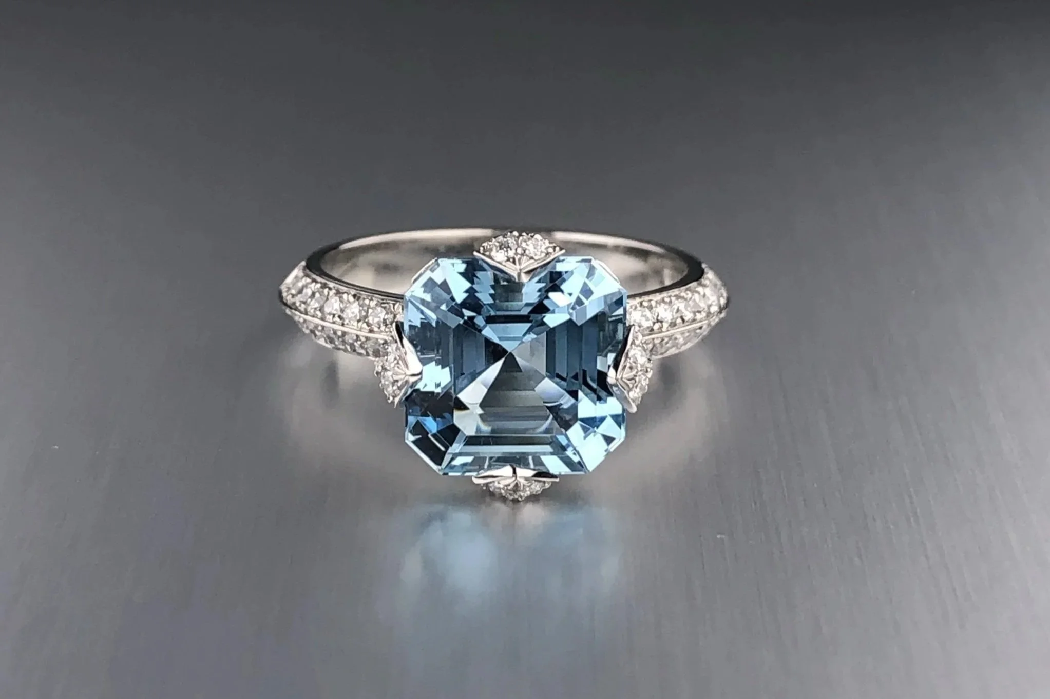 Front view of a custom platinum engagement ring featuring a 2.46 ct Asscher-cut aquamarine with natural diamond accents.