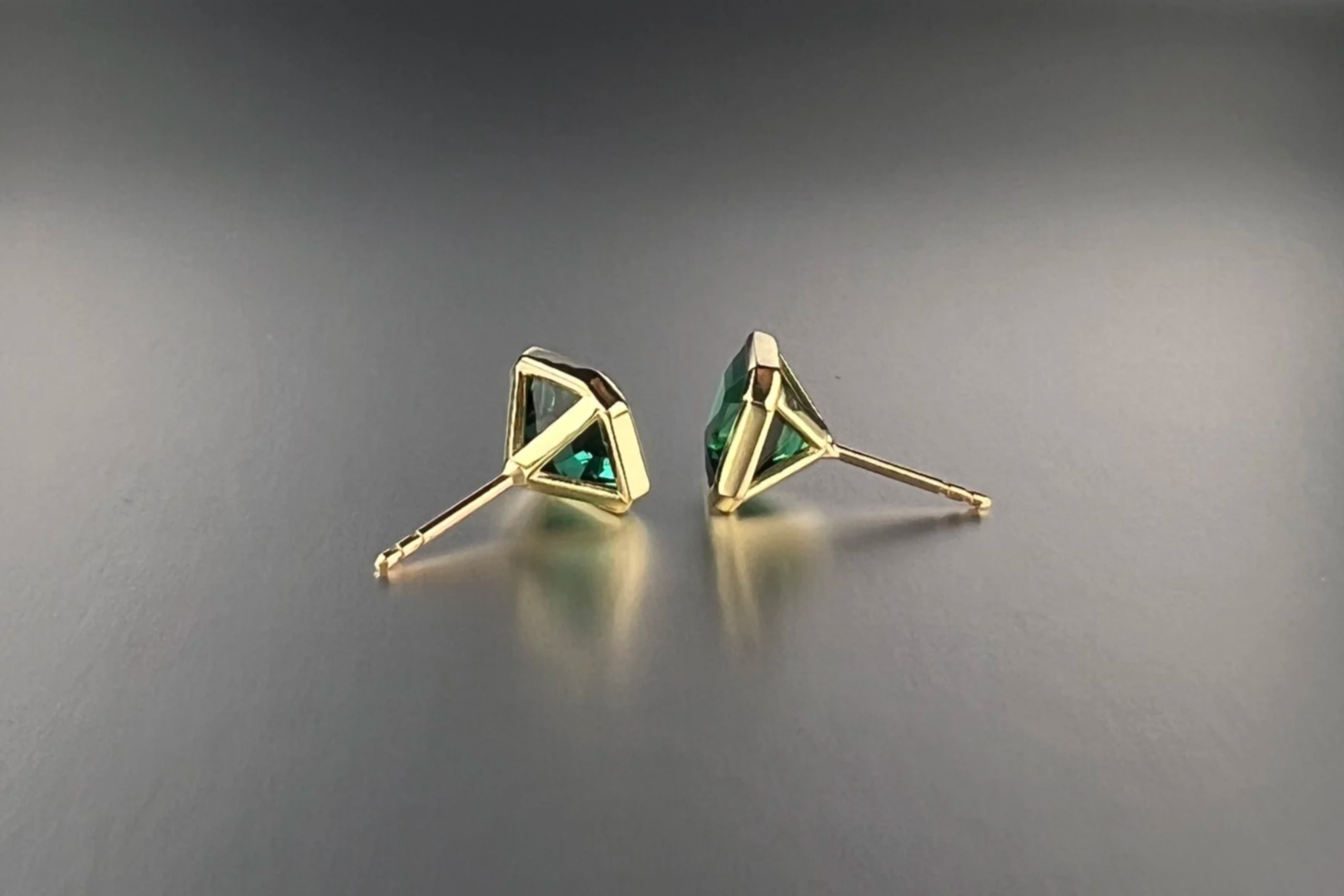 Side view of custom 18k yellow gold bezel-set martini stud earrings featuring 4.44 tcw no-heat lagoon tourmalines from Brazil.