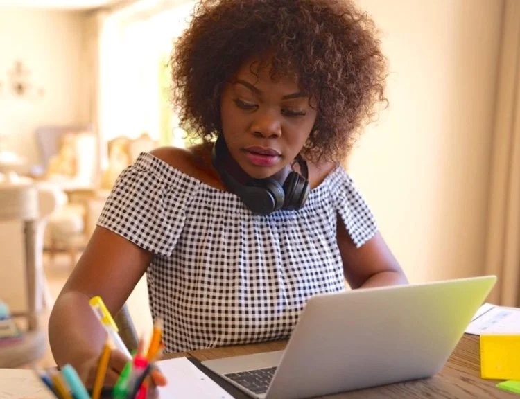 20 something woman studying at desk with laptop