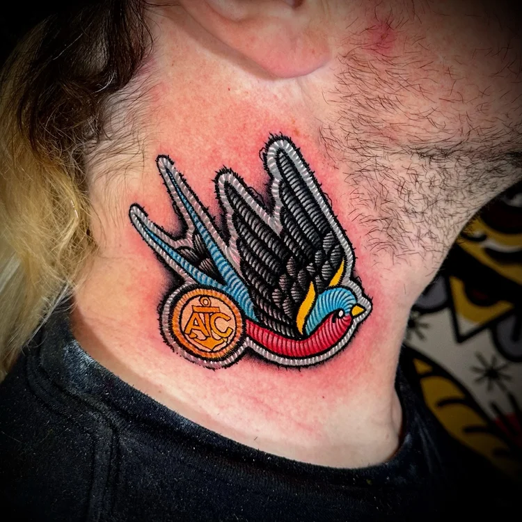 Embroidery-style swallow patch tattoo by CJ Ugarte at Electric Street Tattoo, Fort Lauderdale