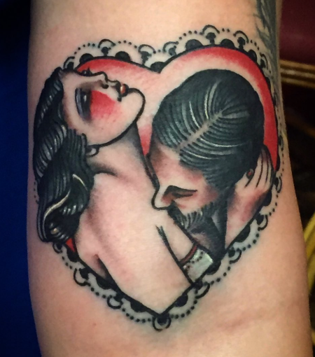 American Traditional lovers’ kiss in a heart frame tattoo by Josh at Electric Street Tattoo, Fort Lauderdale