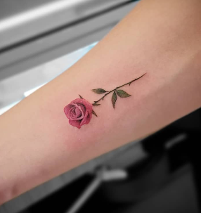 Fine line small red rose forearm tattoo by Edson at Electric Street Tattoo, Fort Lauderdale