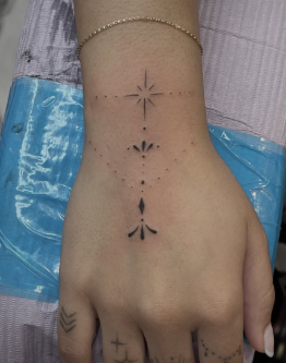 tiny decorative hand tattoo
