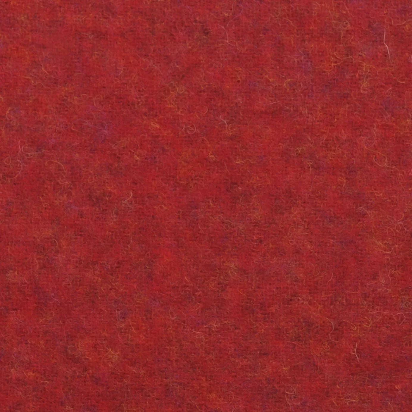 Close-up of red felt fabric with a fuzzy texture and visible fibers.