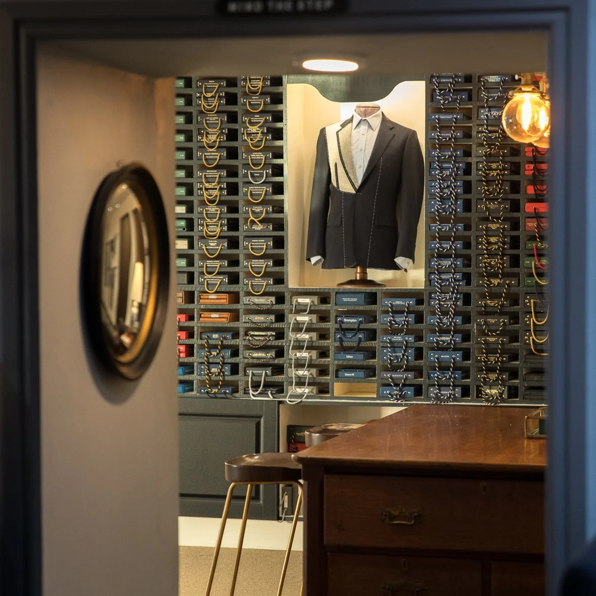 Interior of tailor shop with suit jacket, fabric samples, and sewing tools