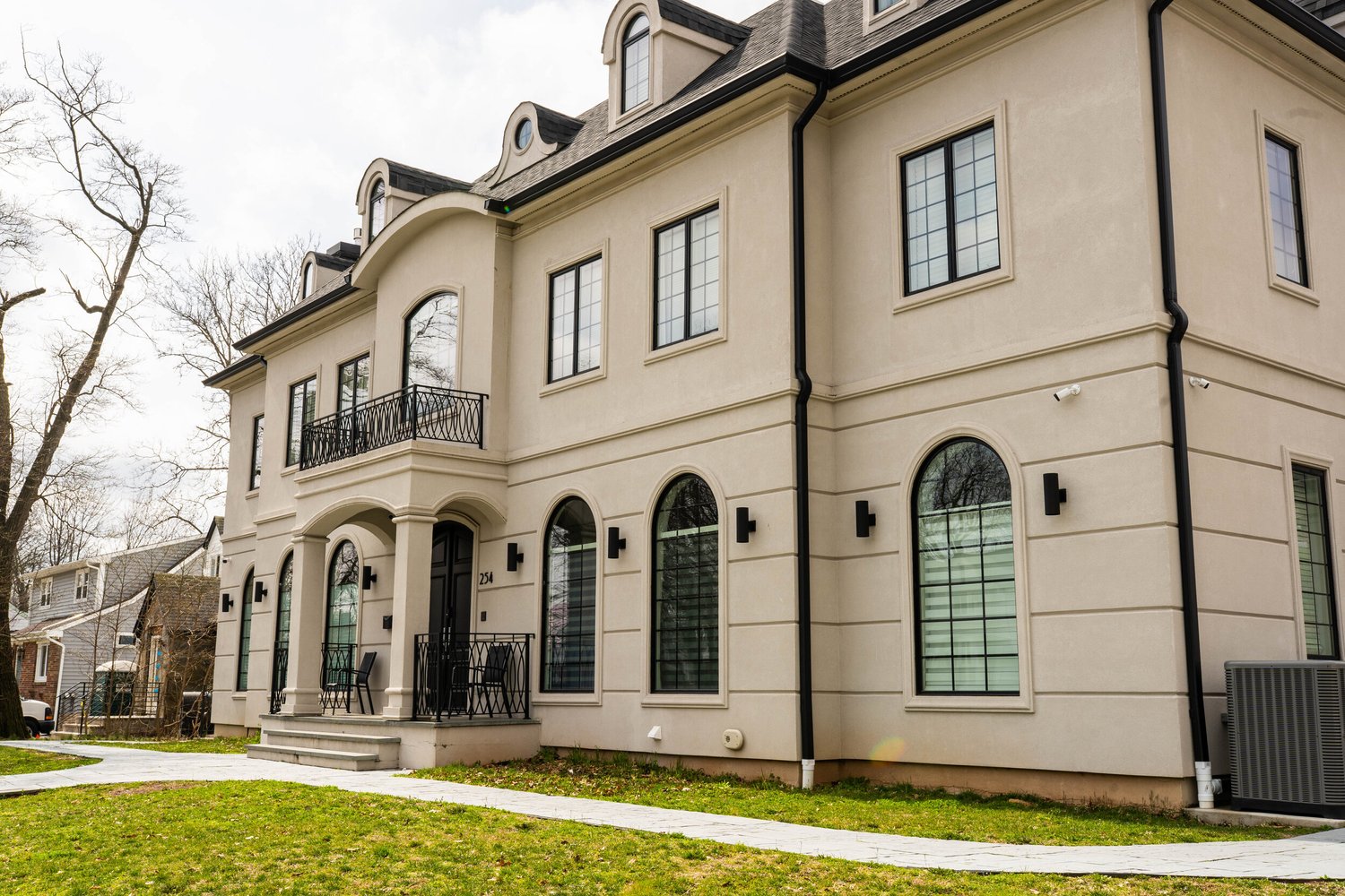 Custom home built by Omar Construction in Bergen County, NJ — French-inspired stucco residence with arched windows