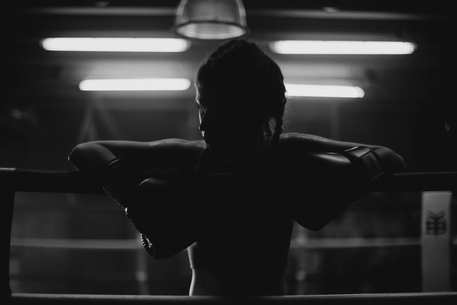 Un boxeur en appui sur les cordes du ring