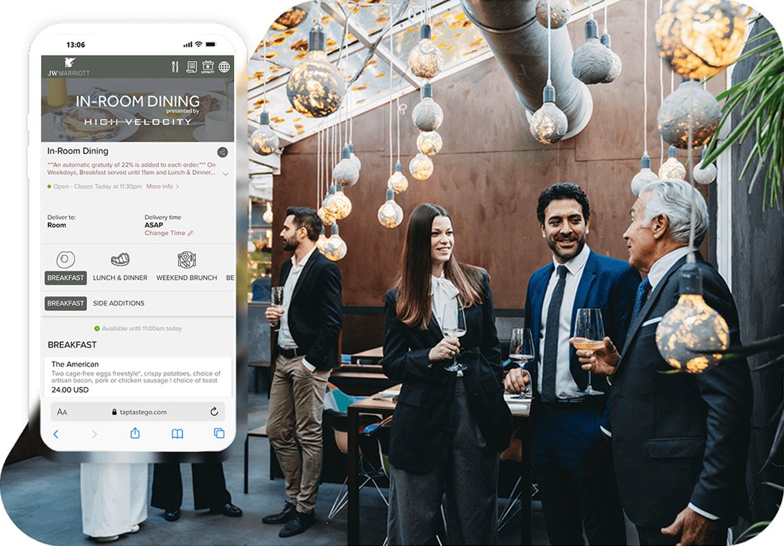 JW Marriott in-room dining menu displayed on a smartphone beside people socialising at a hotel event.
