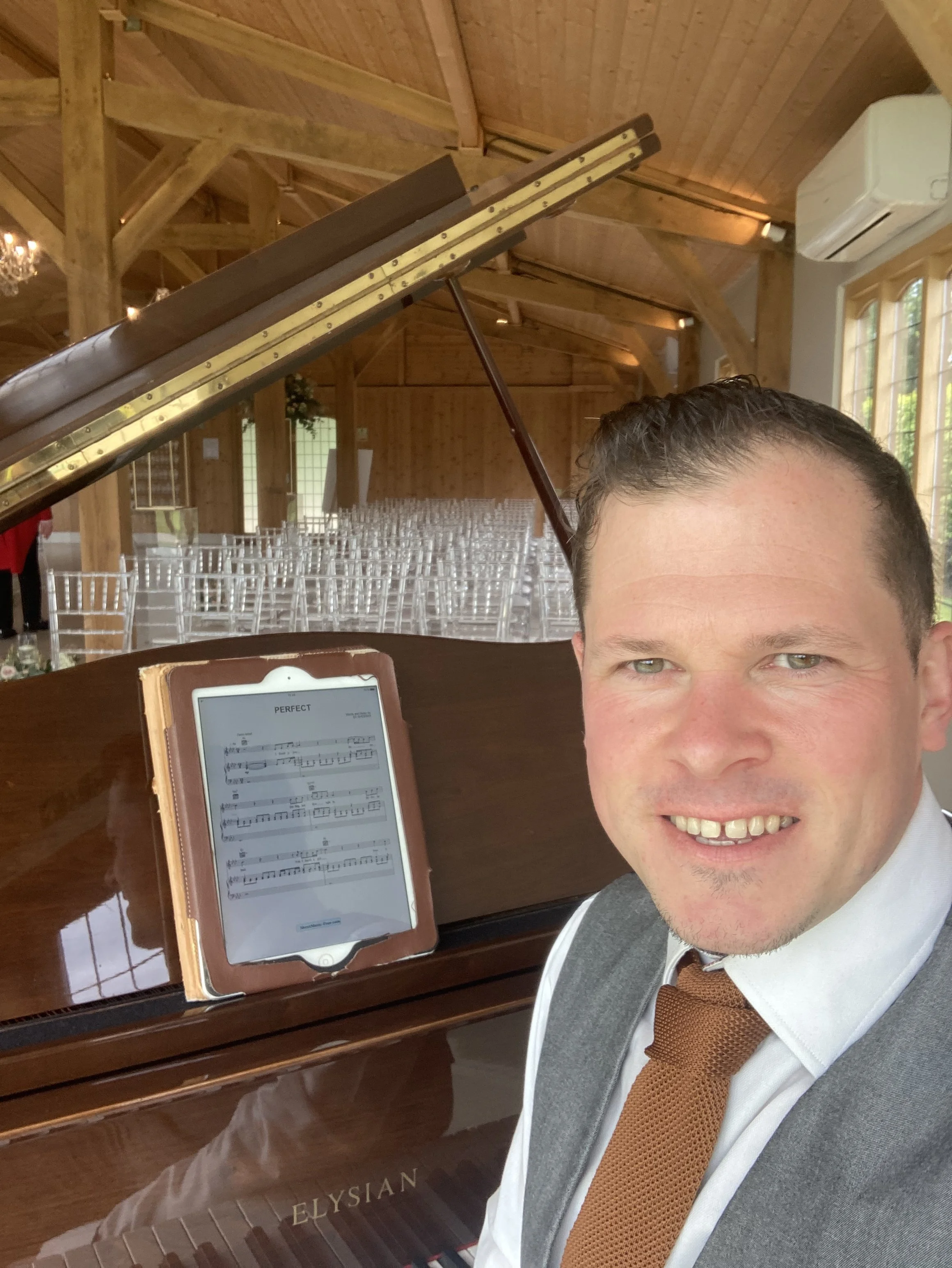 Award winning pianist Chris Morris in the ceremony room at Merrydale Manor in a smart grey waistcoat