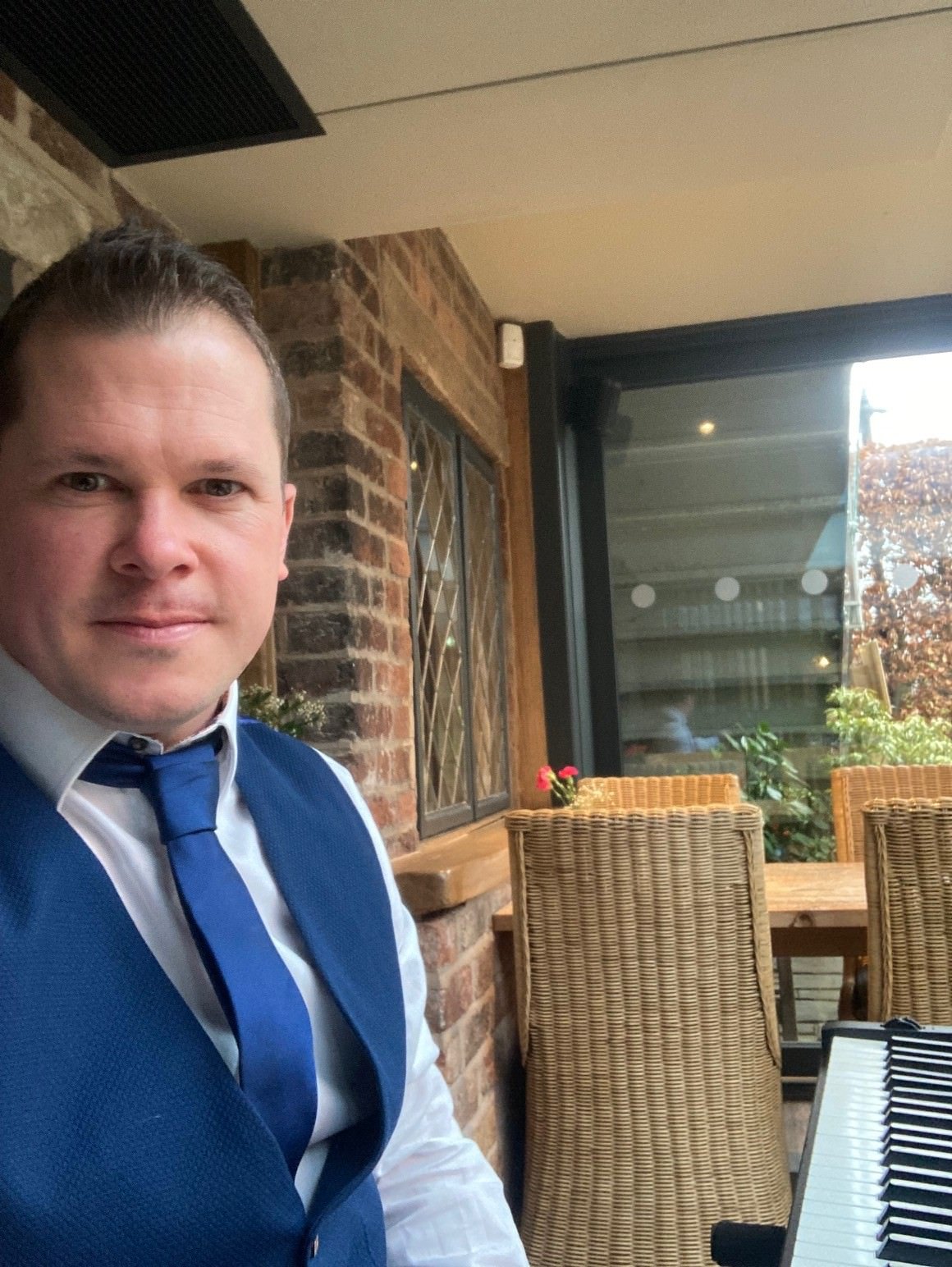 Award-winning wedding pianist Chris Morris playing the piano in the orangery at the Plough Inn, Eaton