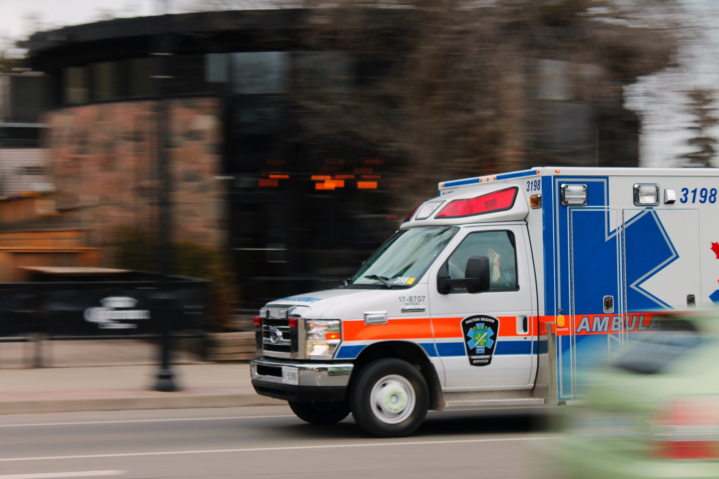 An ambulance in motion, the background blurred.