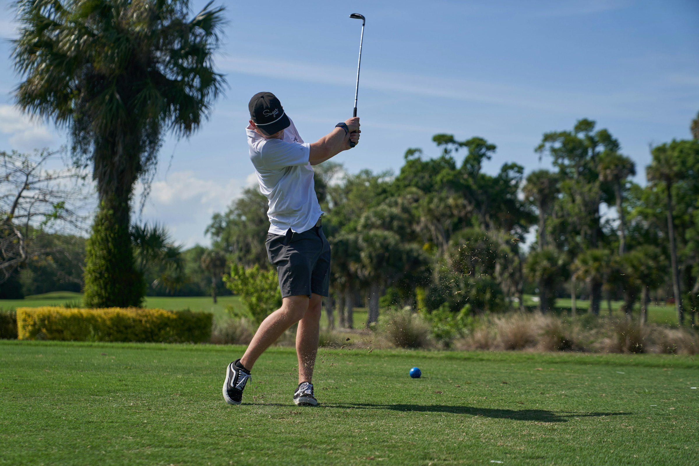 A college golfer swings on the golf course.