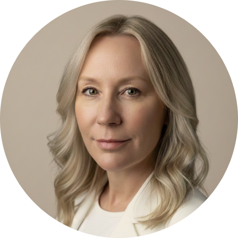 En blond kvinna med axellångt hår och ljus hud, leende, mot en neutral beige bakgrund.