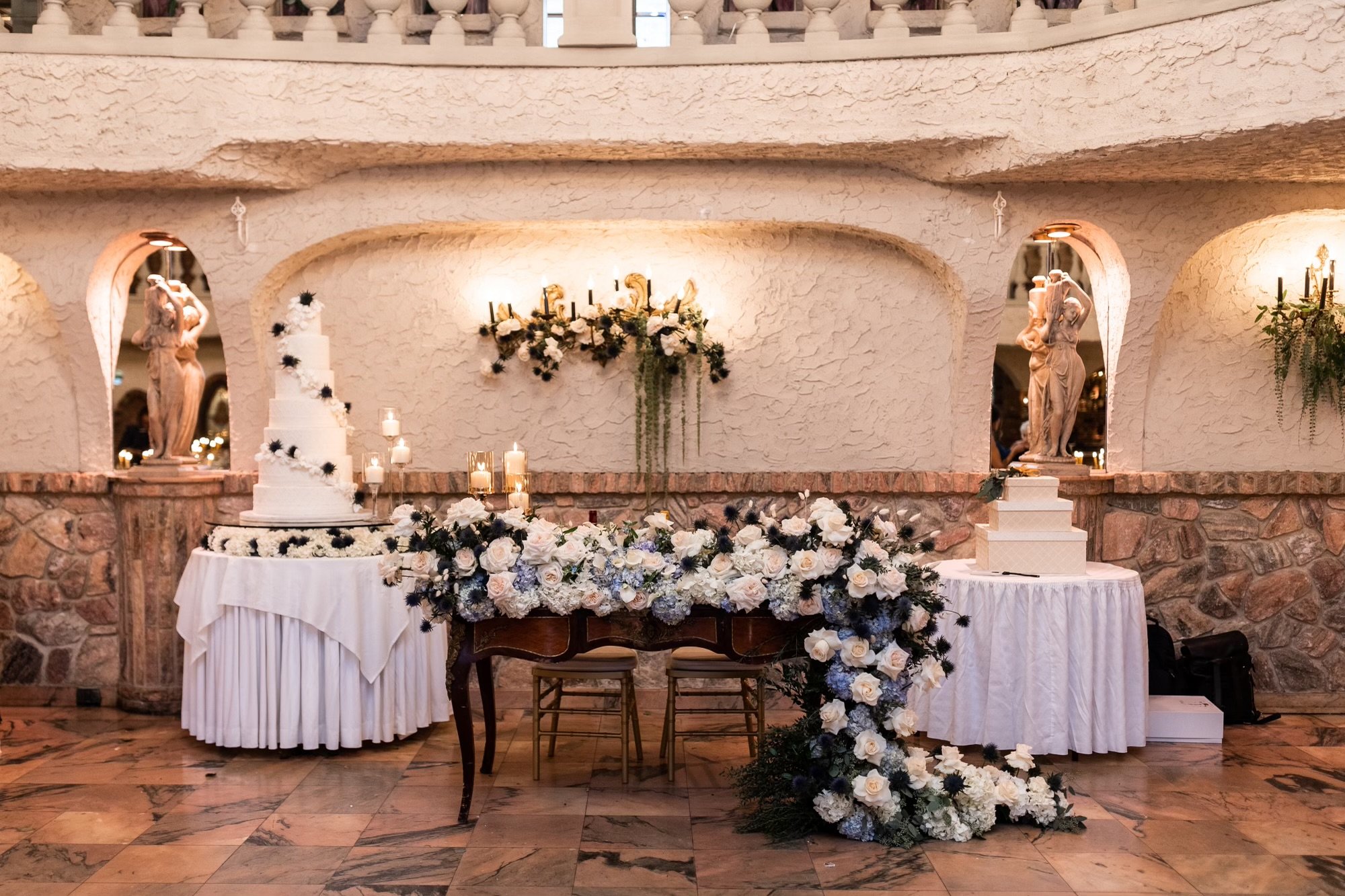 The couple's table at a wedding host by Villa Russo. The wedding cake and gift boxes are next to and behind the main table.