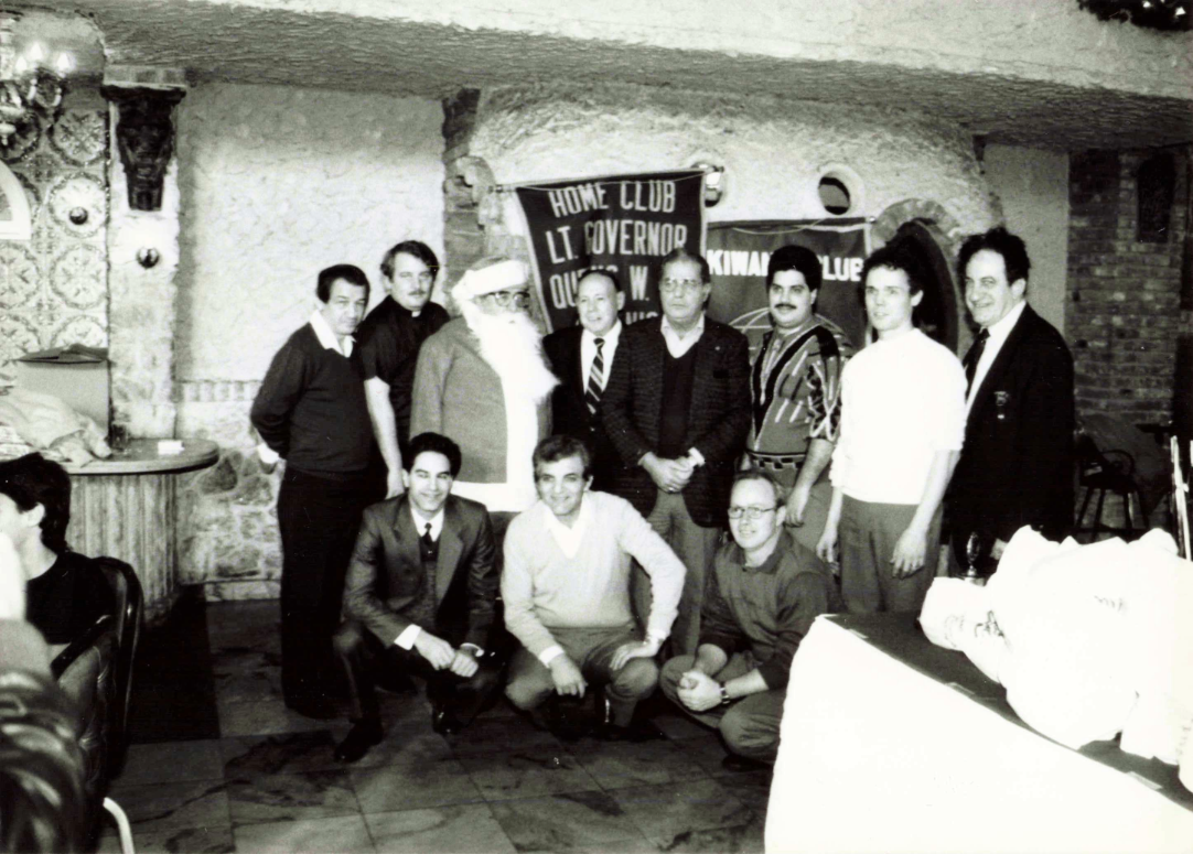 Historic banquet gathering with guests gathered together for a group photo in a event venue.