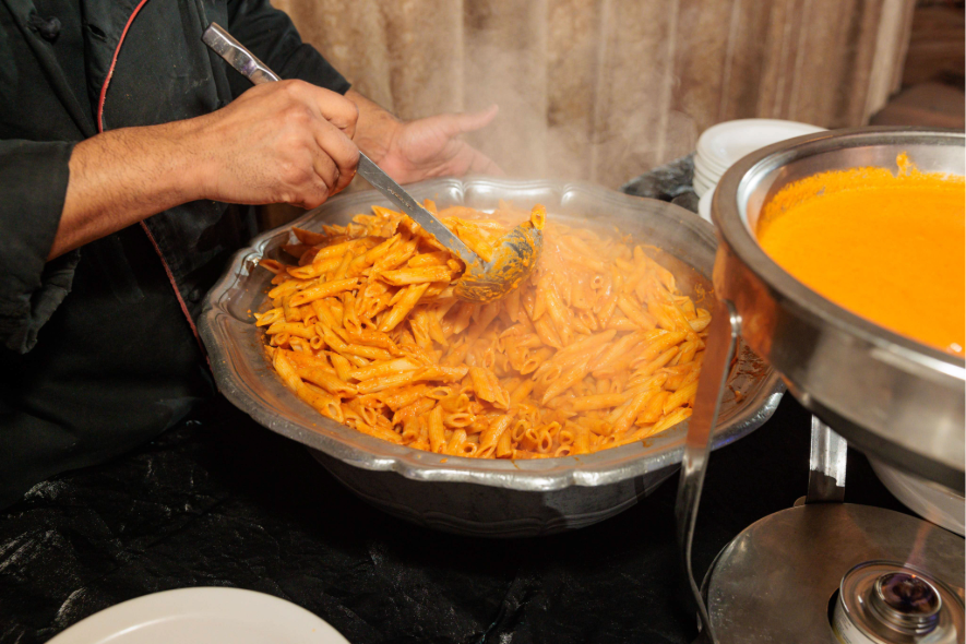 Penne pasta being served from a buffet at Villa Russo in Queens, New York.