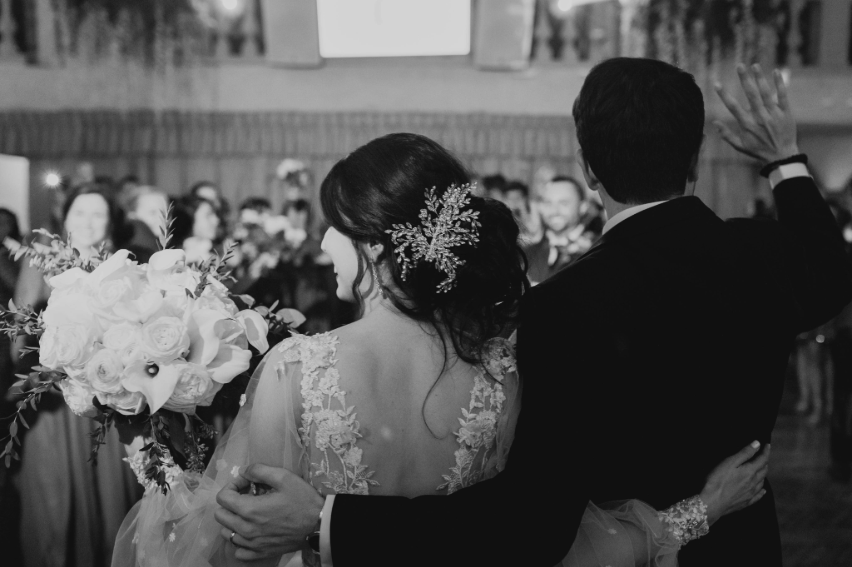 Bride and groom embracing as they greet their wedding guests during their reception at Villa Russo.