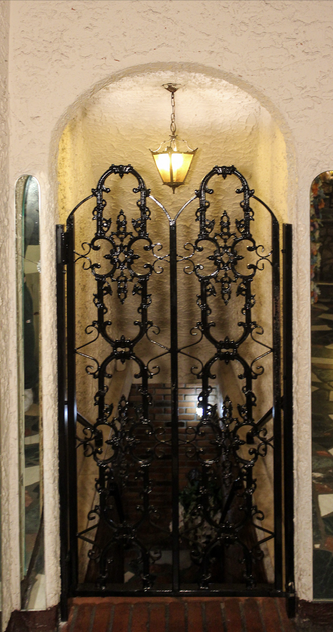 Ornate wrought iron gate inside Villa Russo wedding venue in Queens NY with arched stone entry