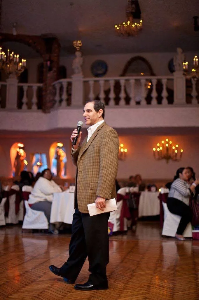 Speaker addressing guests during a seated banquet event.