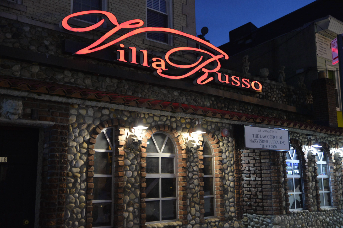 Private entrance to an intimate wedding venue in Queens, New York, with illuminated signage and a separate entrance for event guests.
